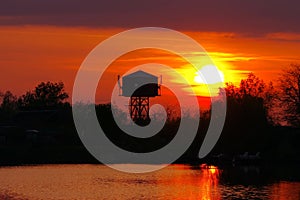 Danube river - landmark attraction in Romania. Red sunset. Colored sunset landscape in natural reserve of the Danube Delta