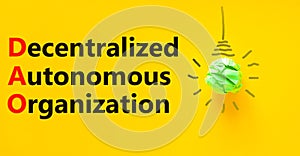 DAO decentralized autonomous organization symbol. Concept words DAO decentralized autonomous organization on a beautiful yellow