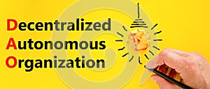 DAO decentralized autonomous organization symbol. Concept words DAO decentralized autonomous organization on a beautiful yellow