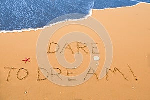 Dare to dream written in the sand photo