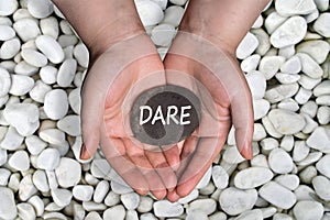 Dare word in stone on hand