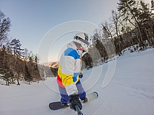 A daring man conquers snowy slopes with style, showcasing skill and thrill as he maneuvers on a snowboard, capturing the