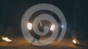 Daring muscular guy in a fire show at night