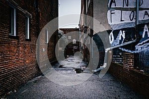 Dark alley and old brick buildings in Baltimore, Maryland.