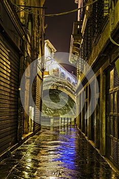 Dark alley in Venice with Rialto Bridge