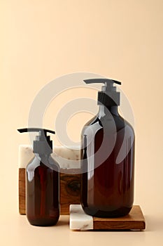 Dark amber glass shampoo and hair gel bottles on wooden and stone podium. Natural beauty product design, cosmetics branding