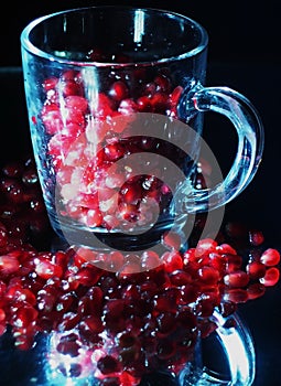 On a dark background, a glass of pomegranate juice