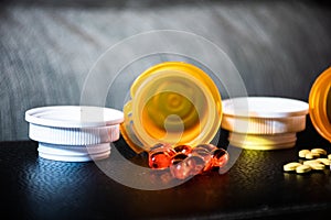 Dark Background with Open Pill bottles and Capsules