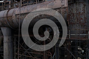 Dark background of rusting metal tubes and pipes, corrosion, industrial backdrop