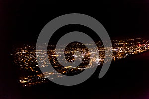 Dark background view of city with lights from aeroplane. Night lights in the city. Aeroplane view of dark nigh above the