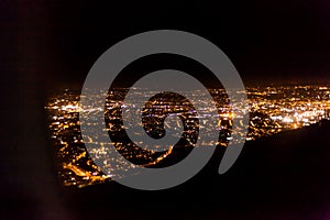 Dark background view of city with lights from aeroplane. Night lights in the city. Aeroplane view of dark nigh above the