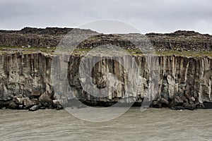 Dark basalt columns and a river running below them, Iceland