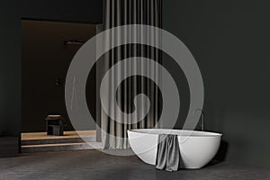 Dark bathroom interior with shover and curtain, bathtub and towel