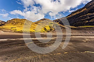 Dark beach in Osin Bay and steep mountain slopes. Saksun, Faroe Islands