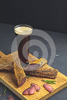 Dark beer in glass and Jerky, basturma, dried meat beef