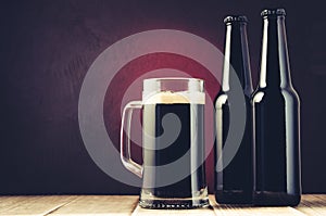 Dark Beer mug and bottles on wooden shelf on a red background/dark Beer mug and bottles on wooden shelf on a red background.