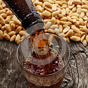 Dark beer is poured into glass from bottle