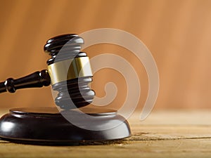 On a dark beige background, a wooden gavel of a judge. The concept is judgment and justice. Crime, punishment, rule of law, judge