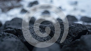 Dark black volcano rocks on the floor with blue background in winter