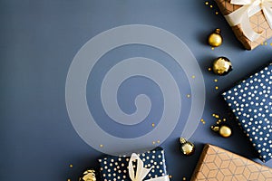Dark blue Christmas background with gift boxes and gold baubles. Flat lay, top view, copy space