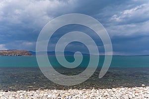 Dark blue clouds and sea or ocean water surface with dramatic seascape