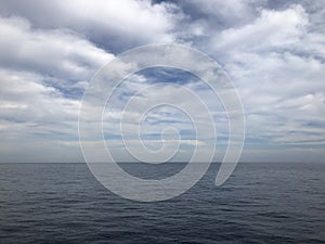 Dark blue clouds and sea or ocean water surface with foam waves before storm, dramatic seascape