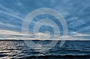 Dark blue evening cloudy sky over the lake