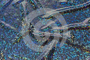 Dark blue fabric with folds and holographic elements. Abstract geometric background or texture