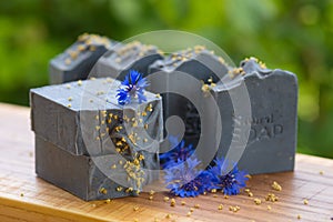 Dark blue handmade soap with blue flowers on a green background