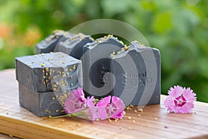 Dark blue handmade soap with pink flowers on a green background