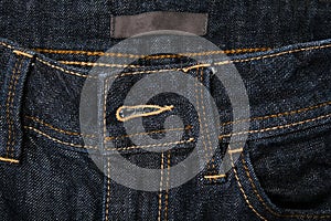 Dark blue jeans denim buttonhole close up