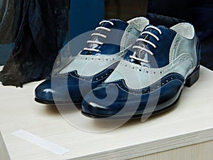 Dark blue men`s leather shoes in a shop window. Men`s fashion shoes, casual design