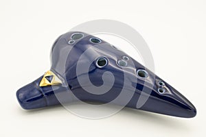 A dark blue ocarina in front of white background photo