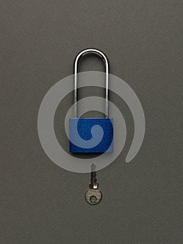 Dark blue padlock with key on a dark gray background