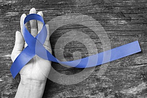 Dark blue ribbon symbolic for colon - colorectal cancer and Acute Respiratory Distress Syndrome ARDS awareness on hand
