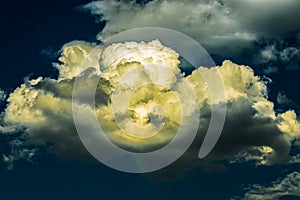 Dark blue sky with yellow cloud illuminated sun