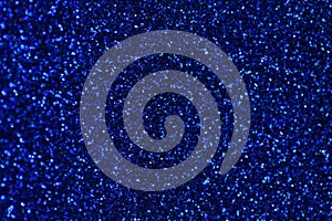 Dark blue sparkling background from small sequins, closeup. Brilliant backdrop