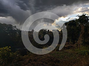 Dark blue stormy cloudy sky natural photo background with Instagram toned effect,Beautiful landscape with green mountains and