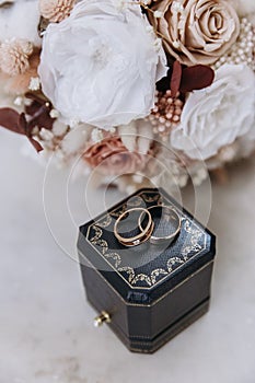 Dark blue wedding box with wedding rings inside on white marble stone. Wedding bouquet of dried flowers. Holiday concept