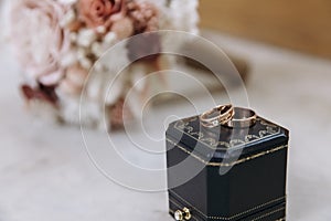 Dark blue wedding box with wedding rings inside on white marble stone. Wedding bouquet of dried flowers. Holiday concept