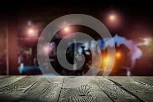 Dark blurred background of bar restaurant and brown wooden table top with space for advertising product.