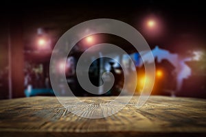 Dark blurred background of bar restaurant and old brown wooden table top with space for advertising product.