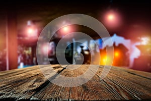 Dark blurred background of bar restaurant and old brown wooden table top with space for advertising product.