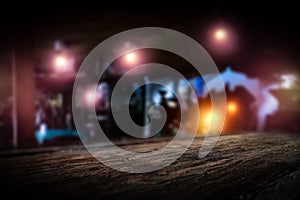 Dark blurred background of bar restaurant and old brown wooden table top with space for advertising product.