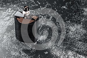 Dark bottle with men`s perfume. Mockup of black fragrance perfume bottle mockup on dark empty background