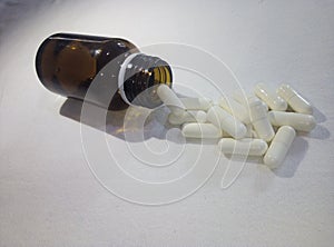 Dark bottle with pill white on white background photo