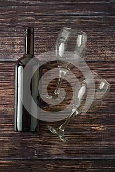 Dark bottle of wine and glasses on wooden background. Top view