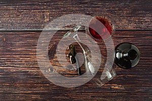 Dark bottle of wine and glasses on wooden background. Top view with copy space