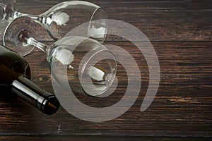 Dark bottle of wine and glasses on wooden background. Top view with copy space