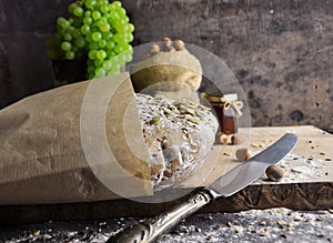 Dark bread, nuts, grapes, honey and a knife